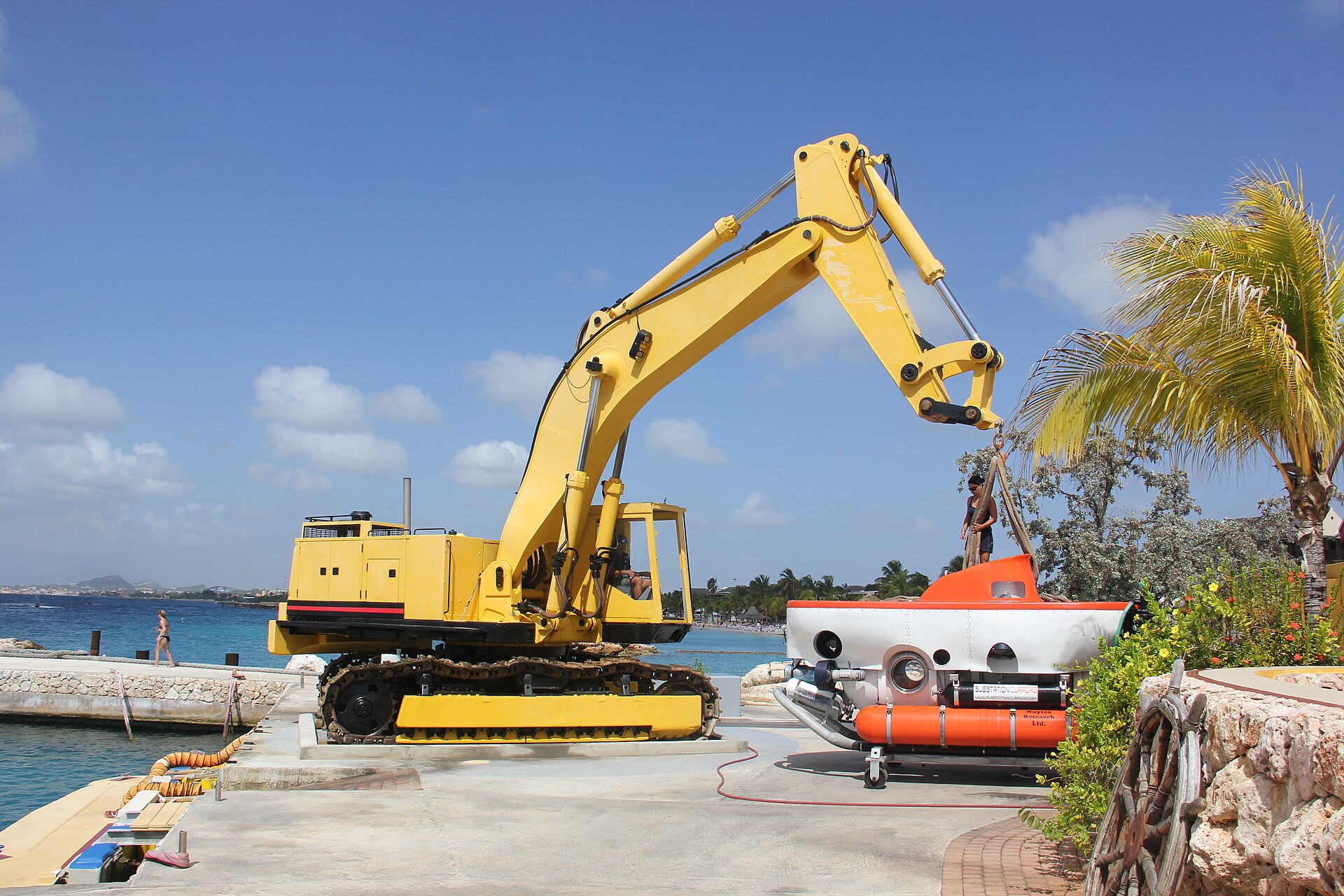 Orange Curasub submersible on the quay next to its yellow launch crane