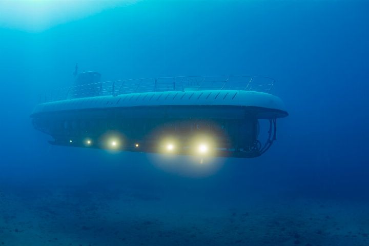 Atlantis IV submarine underwater with its lights on