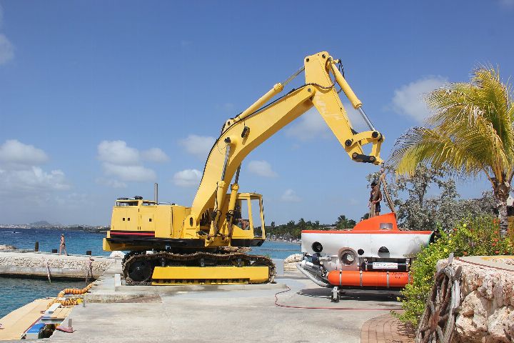 Orange Curasub submersible on the quay next to its yellow launch crane
