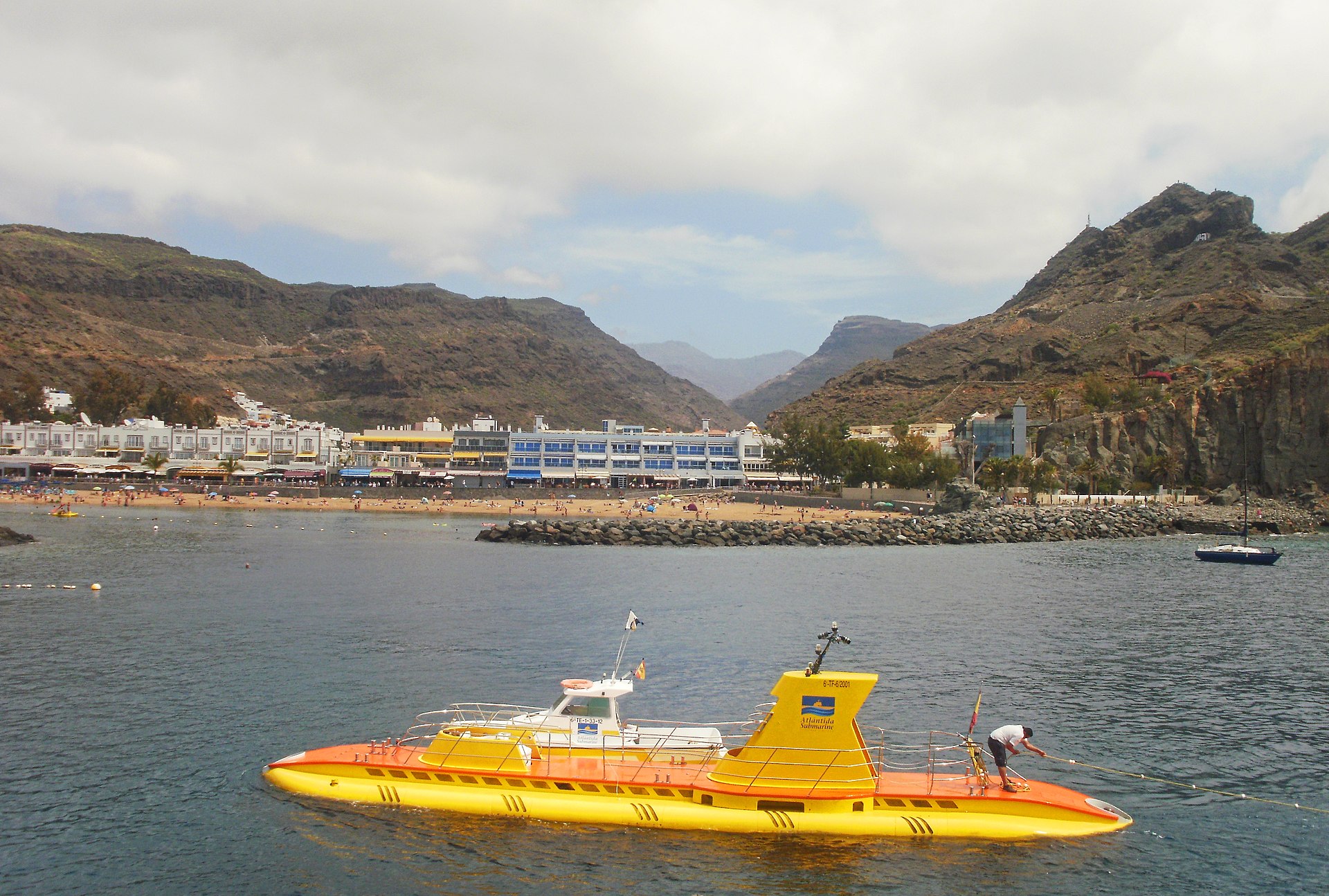 Yellow tourist submarine on the surface in front of the Mogán valley